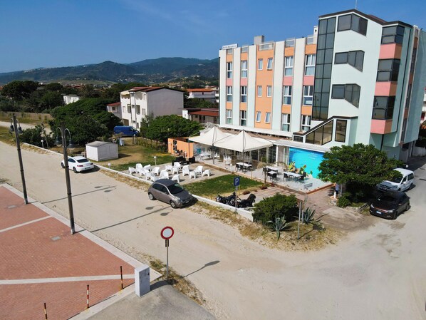 A multi-story hotel with outdoor seating and a swimming pool. - Hotel Rivabella (Davoli)