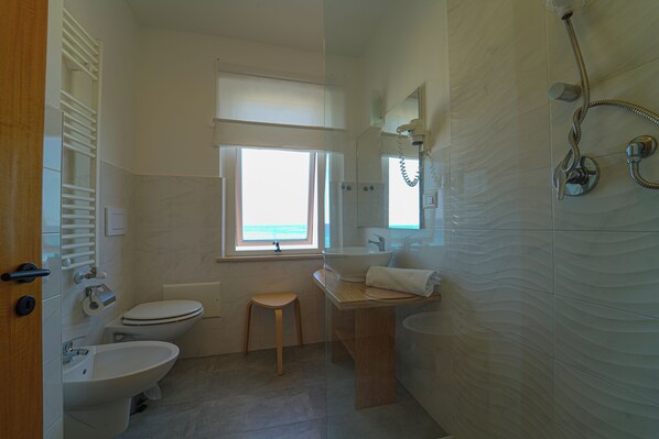 A bathroom with a toilet, sink, and shower. - Hotel Rivabella (Davoli)