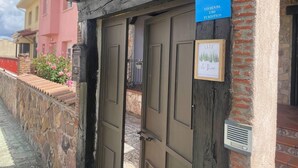A wooden door with a sign reading "VuT Vivienda Uso Turistico" and a framed picture of a landscape. - Casa Rural LA Divisa Hay Lugares Donde uno se Queda y Lugares que Quedan en uno (Boceguillas)