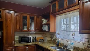 A kitchen with wooden cabinets, a microwave, a coffee maker, and a sink. - Sun Valley Retreat in Montego Bay (Montego Bay)