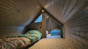 A cozy attic bedroom with two beds, wooden walls, and a sloped ceiling. - Knus Landelijk Verblijf! (Alveringem)