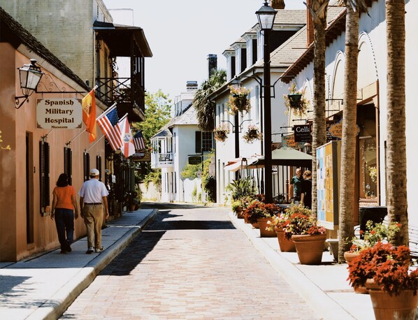 A street with buildings, including a Spanish Military Hospital Museum, and a restaurant named Cella.