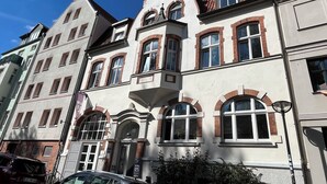 A historic building with multiple windows, a prominent corner entrance, and a sign indicating it is a hostel. - Blue Doors Hostel Altstadt (Rostock)