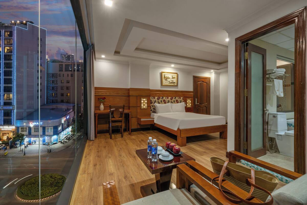 Une chambre d’hôtel avec un lit, une table de chevet et une vue sur le paysage urbain.