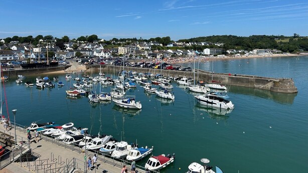 A marina with boats docked, a pier with people, and a beach in the background. - Harbour Stays - The Marine Centre (Saundersfoot)