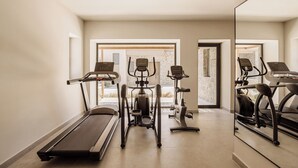 A home gym with a treadmill, elliptical, and stationary bike.