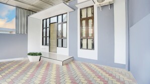 Un edificio moderno con grandes ventanales, techo plano y suelo pavimentado.