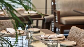 A dining table set with plates, glasses, and a napkin.