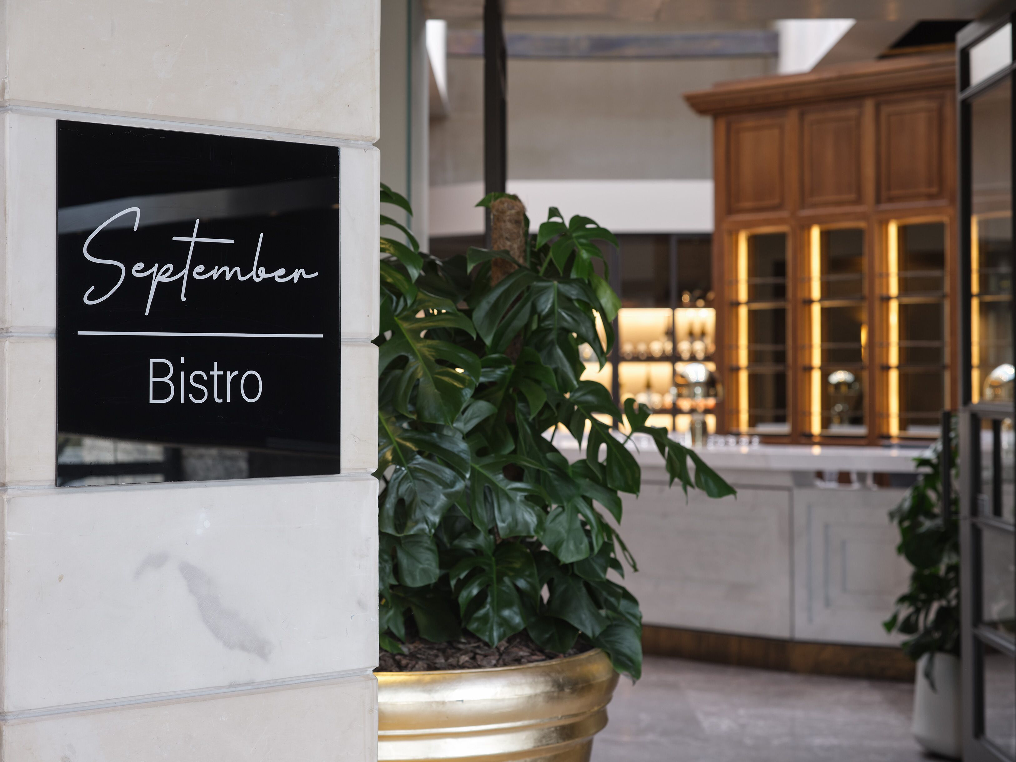 A sign for 'September Bistro' with a potted plant nearby.