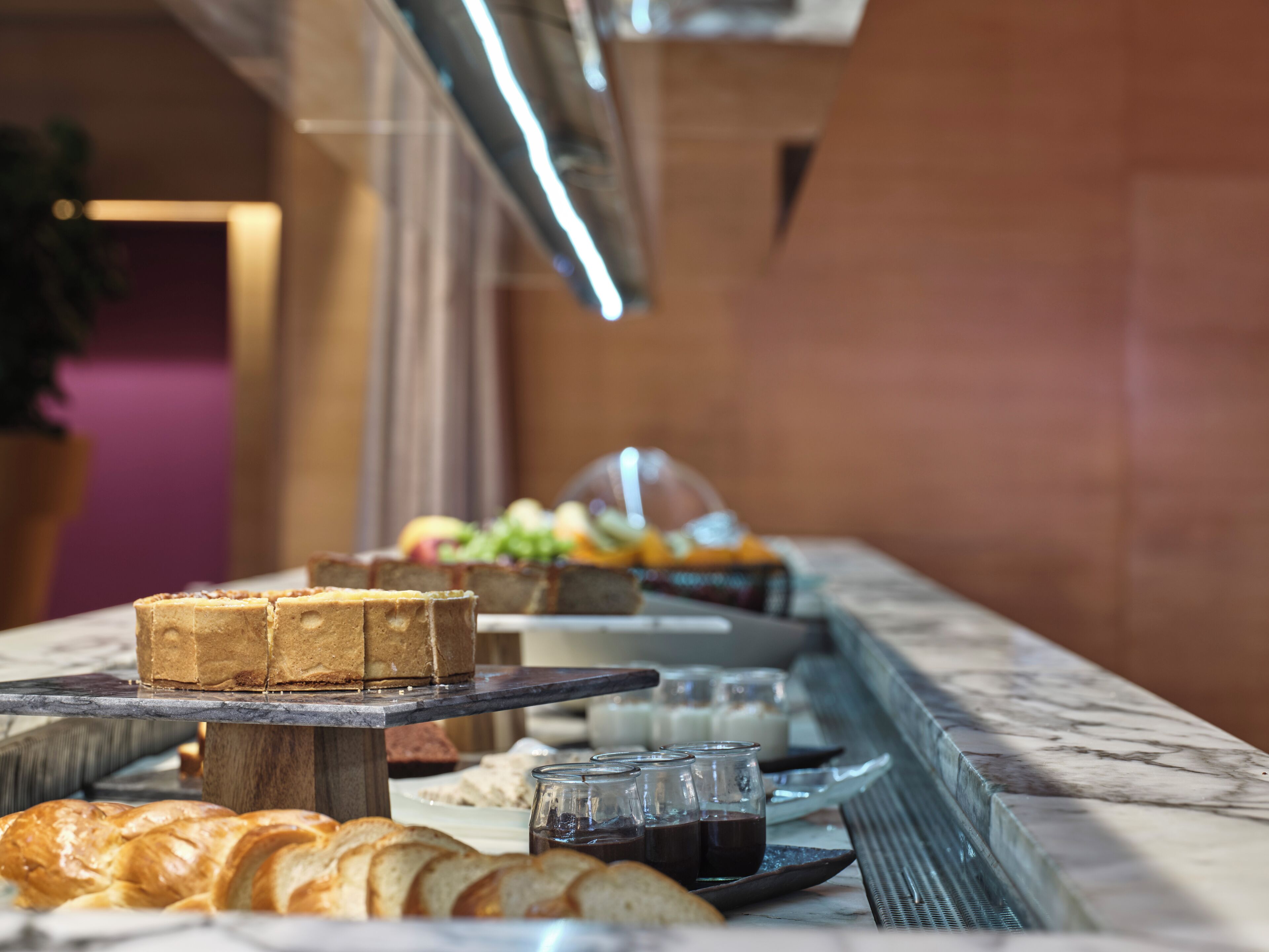 Een buffet met diverse etenswaren, zoals brood, gebak en drankjes.