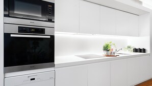 Una cocina moderna con horno integrado, microondas y lavavajillas.