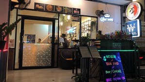 A restaurant with a neon sign for 'Corona' and a signboard advertising Mexican and Thai food. - Butlers WDH (Bangkok)