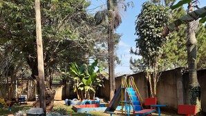 Un parque infantil con columpios de neumático, un tobogán y un balancín.