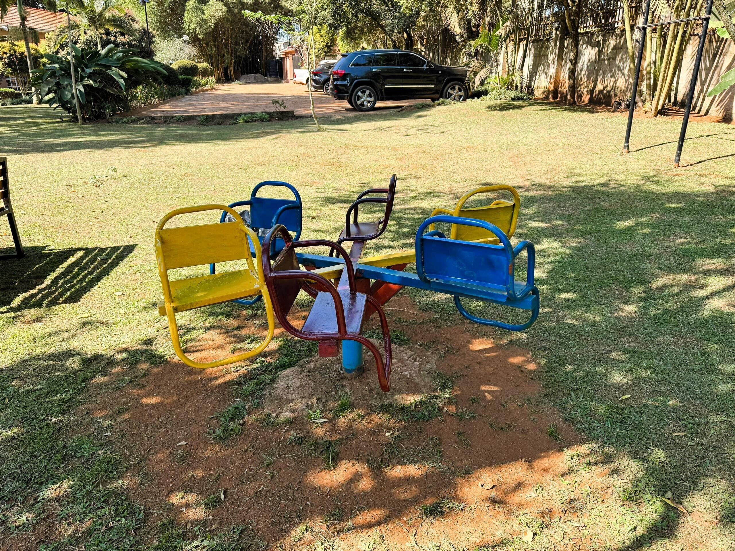 A playground with a seesaw and swings in a grassy area.