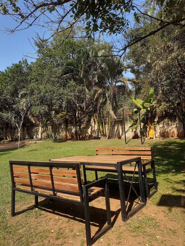 Un parque con un banco de madera y una mesa de picnic.