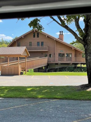 A two-story lodge with a covered deck and a parking area. - Morning Tee Times  Walk to Golf  Summer Stay (Mancelona)