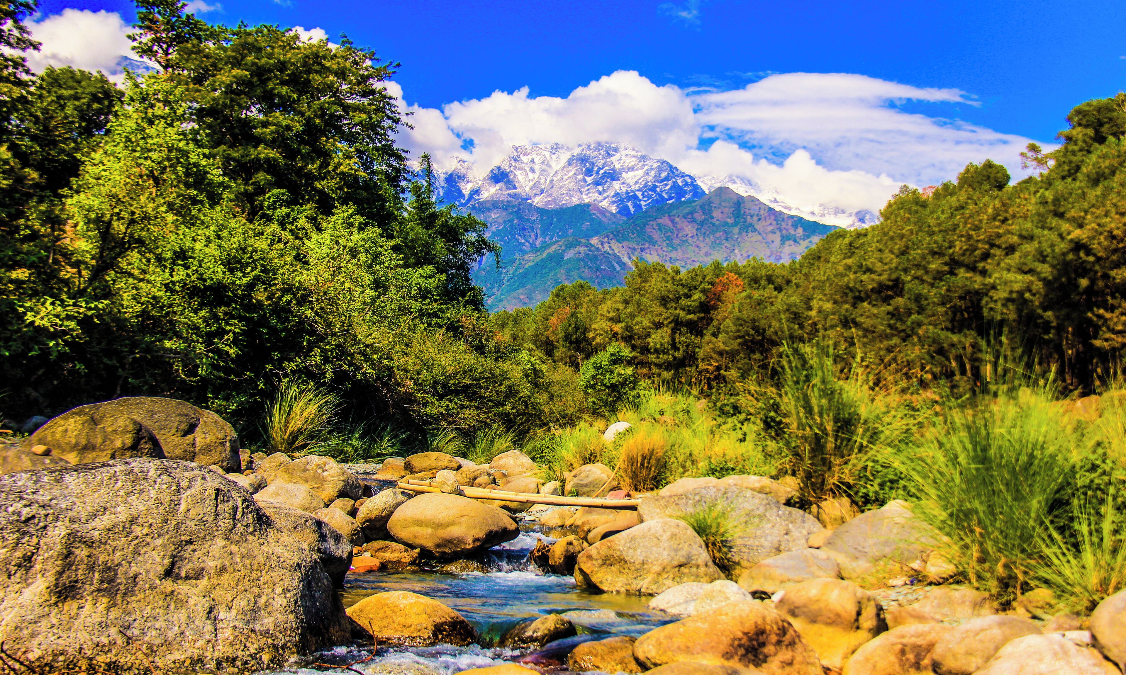 Un río serpentea a través de un paisaje rocoso, con una cordillera de montañas al fondo.