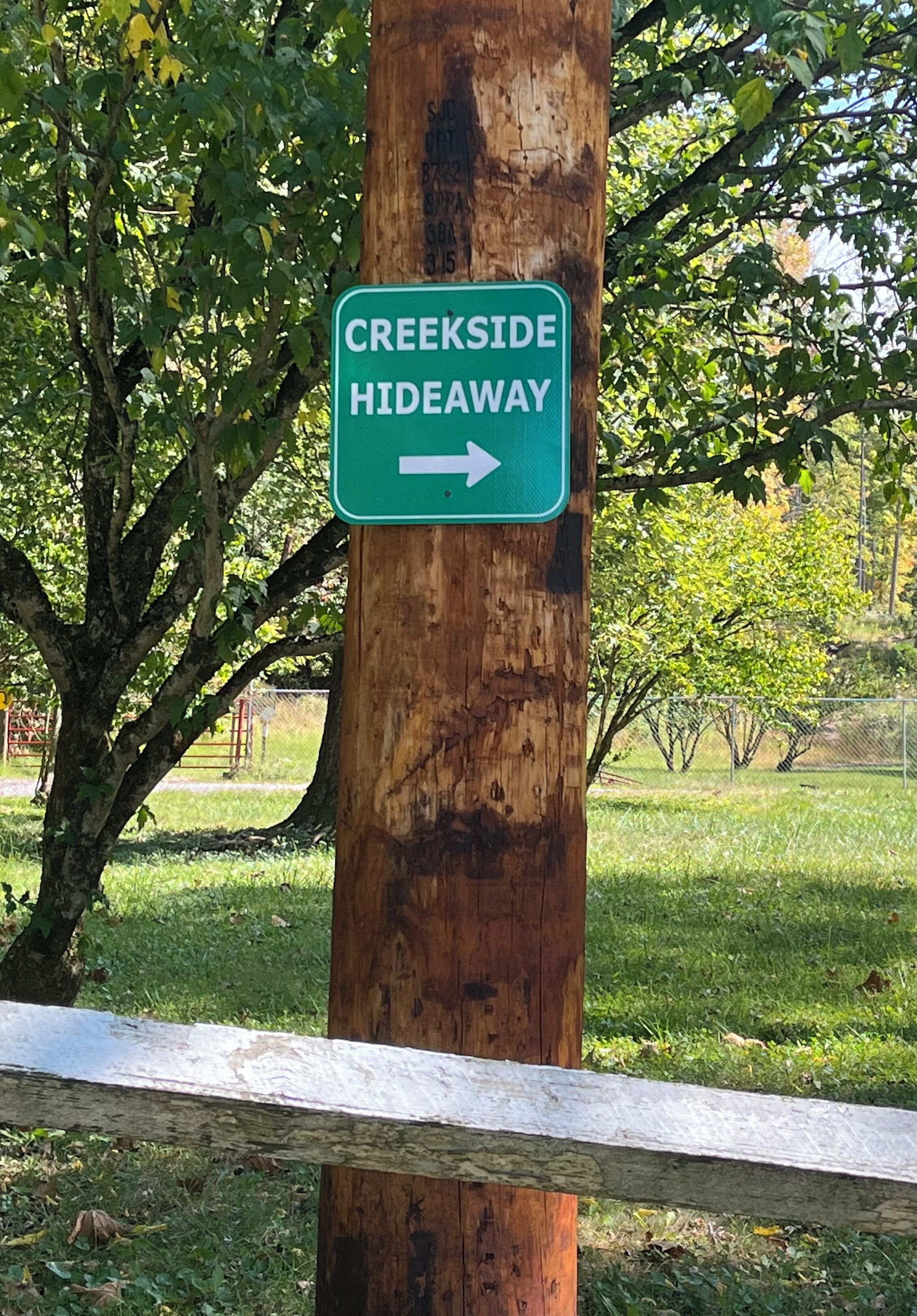 Placa de madeira indicando a direção para Creekside Hideaway.