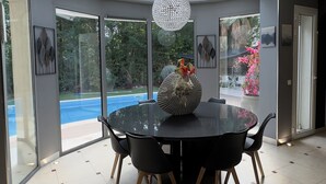 Un comedor moderno con una mesa redonda, sillas negras y un centro de mesa decorativo.