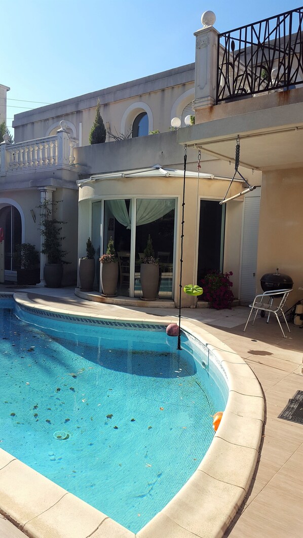 Piscine extérieure en saison, chaises longues