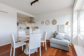 Relax in this stylish living space with a round dining table, comfortable sofa, and floor lamp.