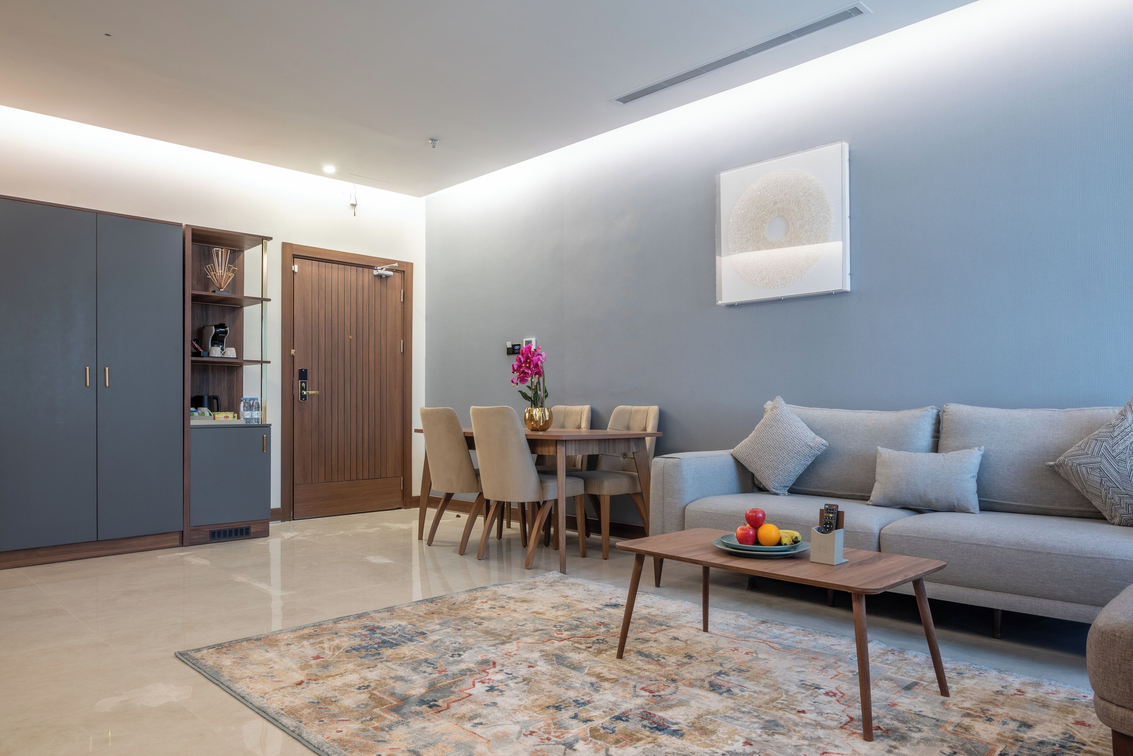 A modern living room with a sofa, coffee table, and dining area.
