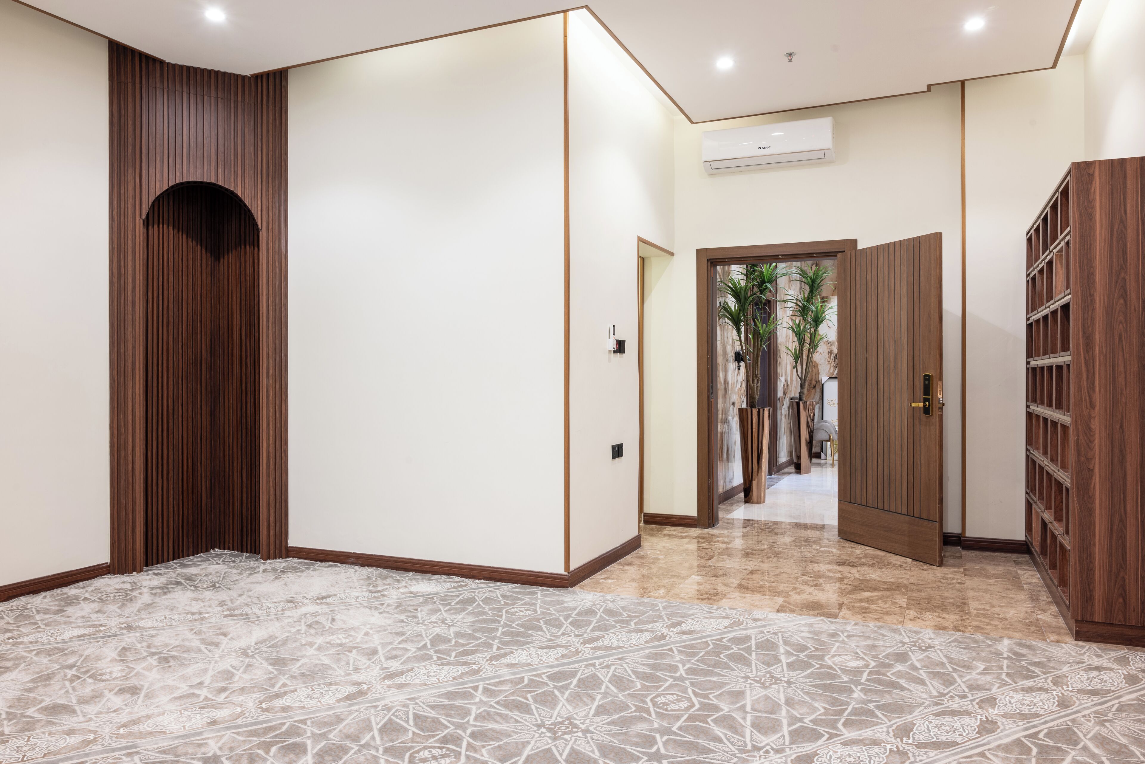 Un pasillo con piso estampado, paneles de madera en las paredes y una puerta que da a una habitación con armario.