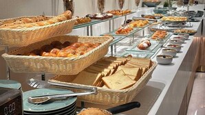 Un buffet con diversi pani e dolci, una sveglia e decorazioni a parete.