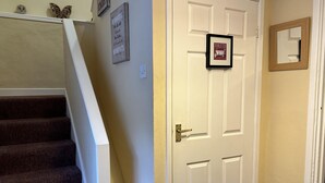 A staircase with carpeted steps leading to a white door with a framed picture. - Llanidloes - Sleeps 7 - Parking - Pet Friendly (Llanidloes)