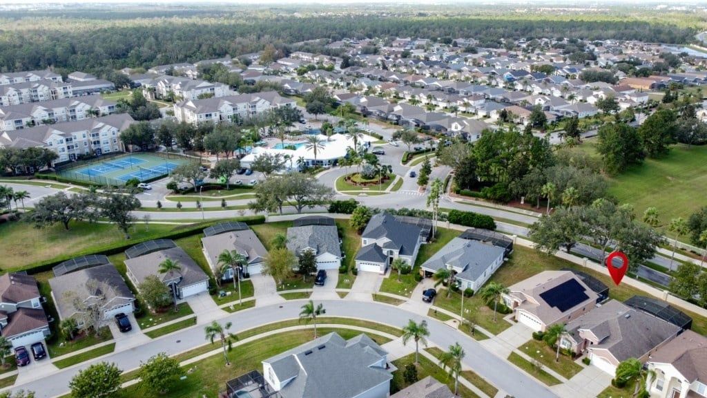 A residential area with houses, a tennis court, and a swimming pool.