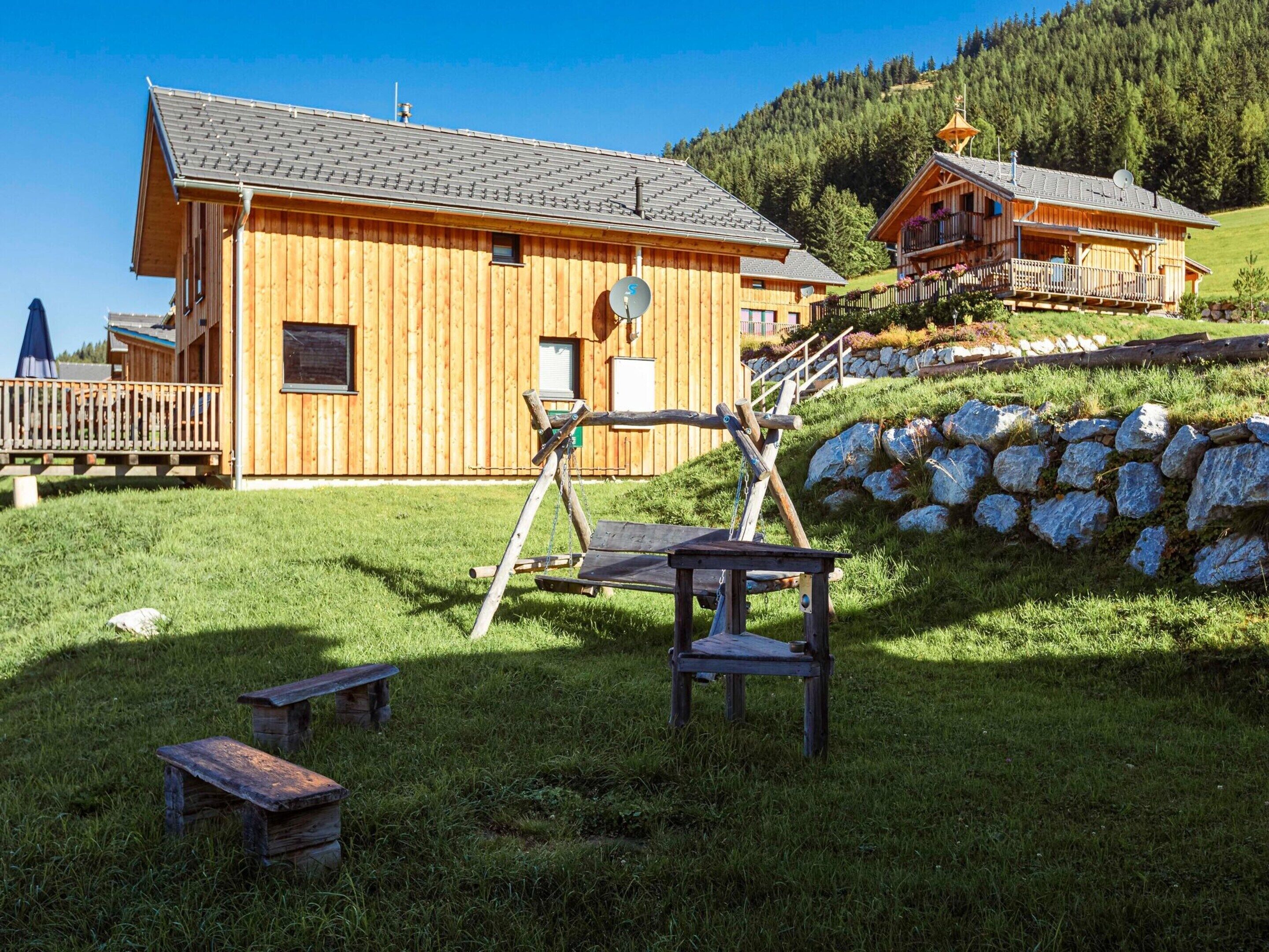 A wooden lodge with a stone wall and a wooden deck.