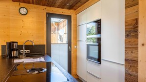 Eine moderne Küche mit schwarzem Arbeitsplatz, Edelstahlgeräten und Holzwänden.