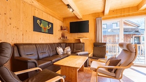 A wooden interior with a leather sofa, a wooden coffee table, and a reclining chair. - Chalet in Hohentauern Near Ski Slopes (Hohentauern)