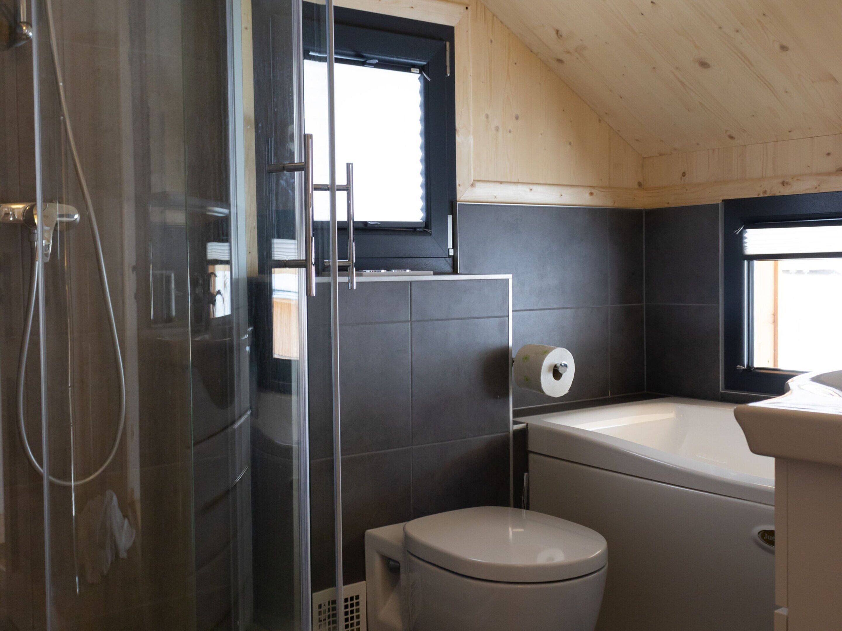 Ein modernes Badezimmer mit Duschkabine, Toilette und Badewanne.