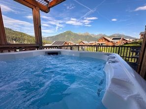 A hot tub with a view of mountains and wooden cabins. - Chalet in Hohentauern Near Ski Slopes (Hohentauern)