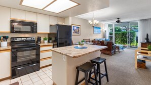 A modern kitchen with a central island, built-in appliances, and a dining area with a view.