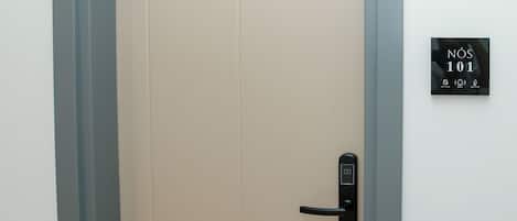 A closed door with a modern keypad lock and a sign indicating room number 101.