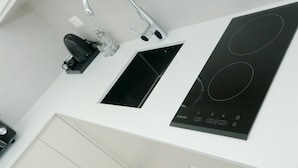 Une cuisine moderne équipée d’une cuisinière intégrée, d’un évier et d’un robinet.
