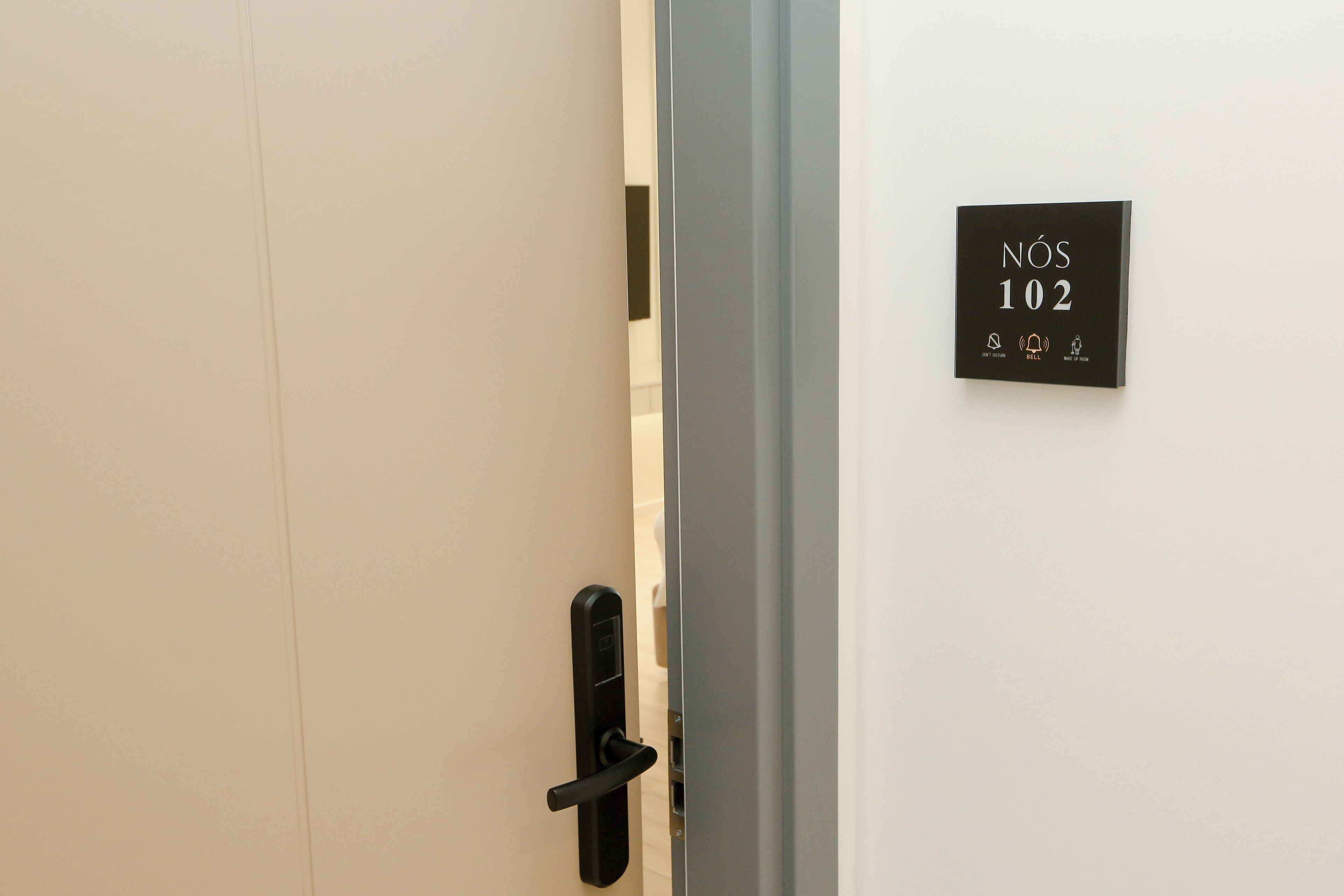 A hotel room door with a digital lock and a sign indicating room number 102.