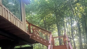 Una escalera de madera con luces cálidas que lleva a una terraza de madera.