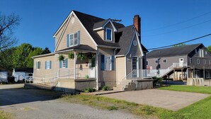 Une maison à deux étages avec un porche à l’avant, un garage et une allée.