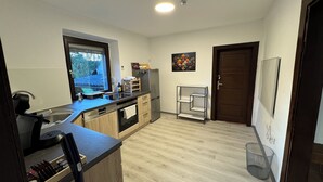 Een moderne keuken met een inbouwoven, een spoelbak en een raam met uitzicht op een tuin.