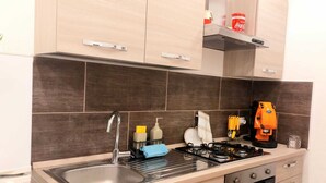 A kitchen with a sink, stove, oven, and cabinets.