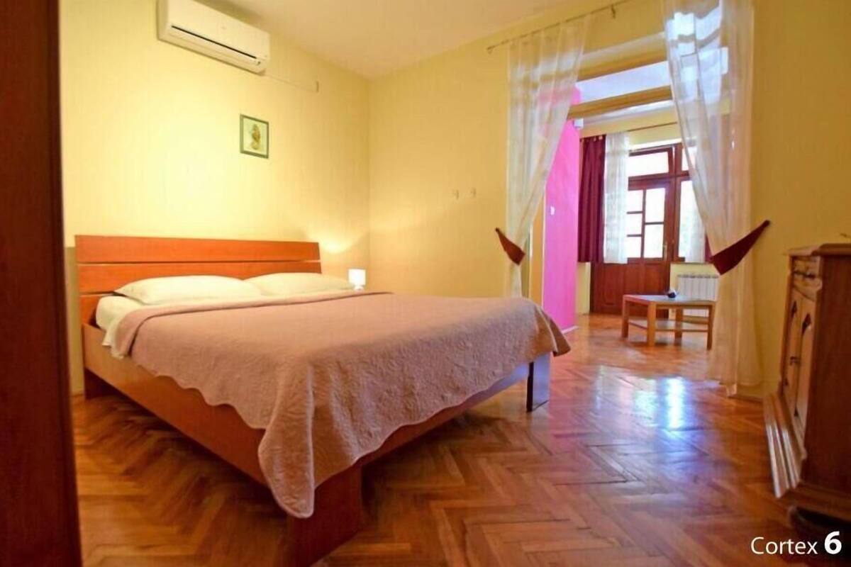 A bedroom with a wooden bed, a nightstand, a chair, and a wardrobe.