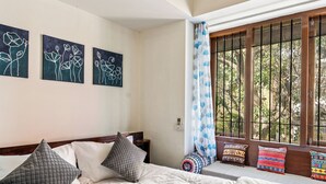 A bedroom with a large bed, a window with bars, and three wall-mounted artworks. - 🌳 Namma Woodland Villa | Golf Course Views (Bengaluru)