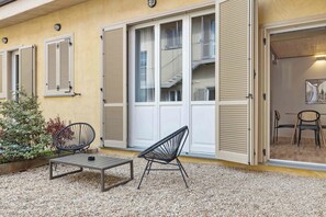 A building with a balcony, a table, two chairs, and a small garden area. - Limehome Rome Via Fortebraccio (Rome)