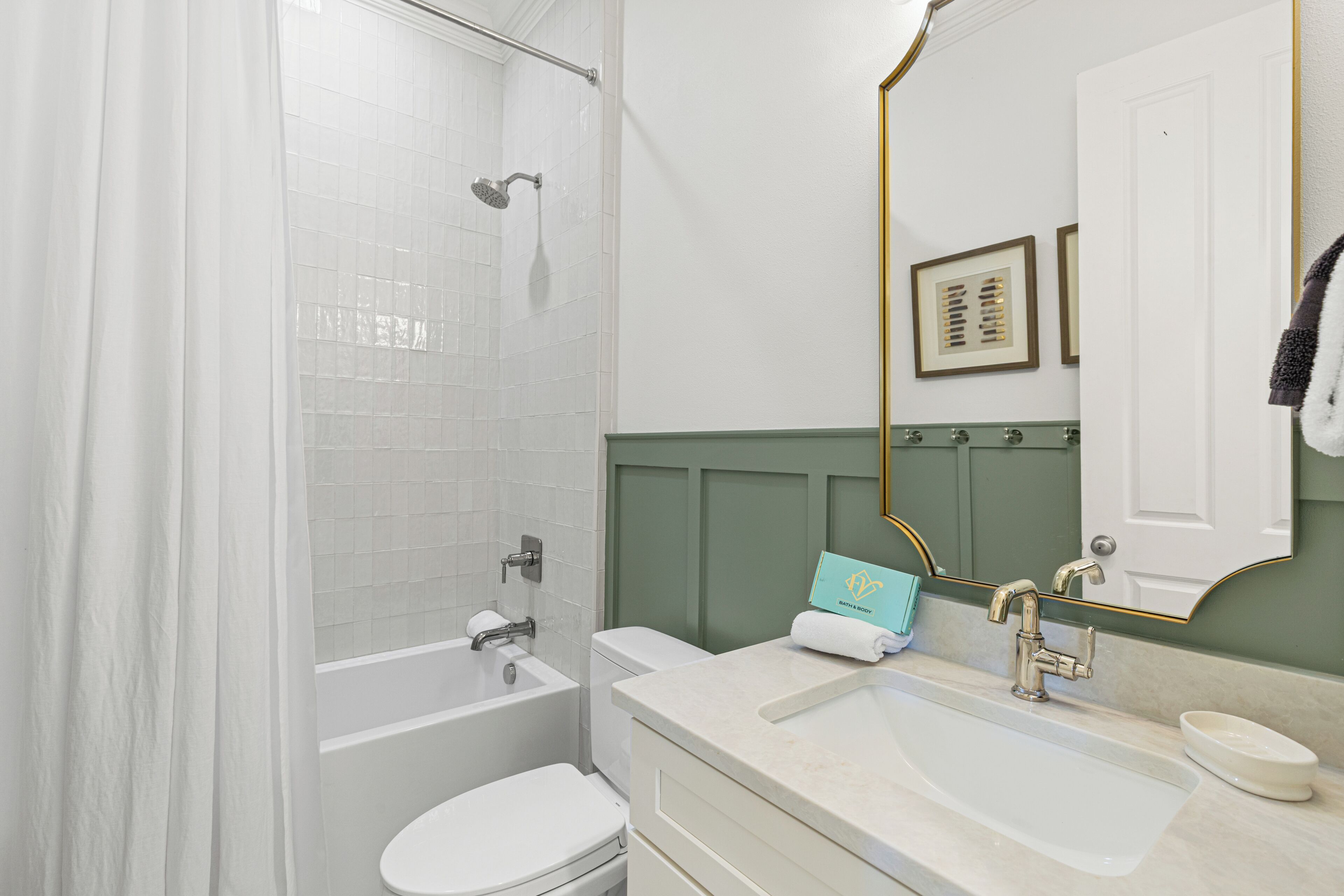 Une salle de bain avec une baignoire, des toilettes, un lavabo et un miroir.
