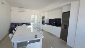 A modern kitchen with white cabinets and a stainless steel refrigerator.