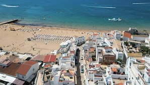 A coastal town with a beach, buildings, and boats.