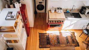 A compact kitchen with a washing machine, a toaster, and a coffee maker. - Petite Maison: Hip & Historic (Telluride)